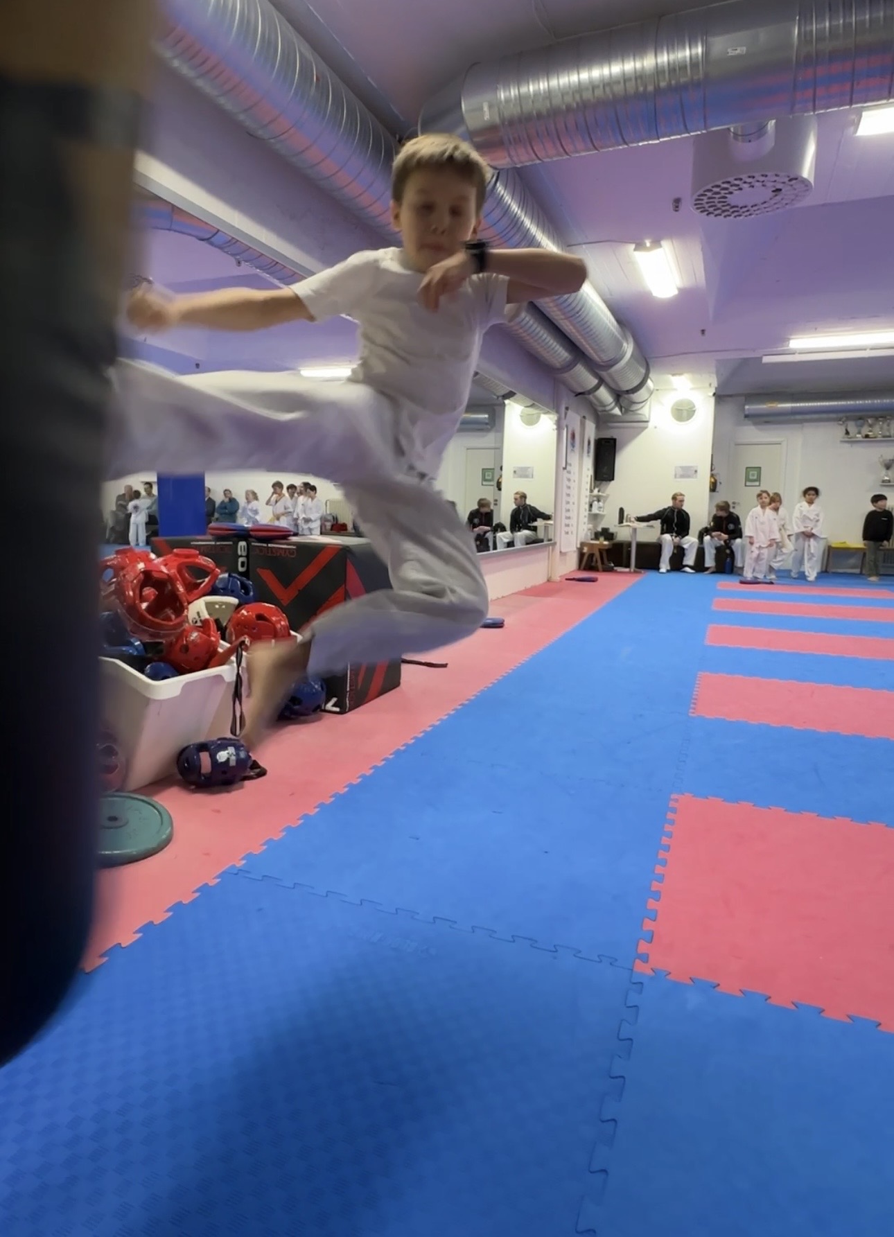 Pojke utför hoppspark under Taekwondoträning