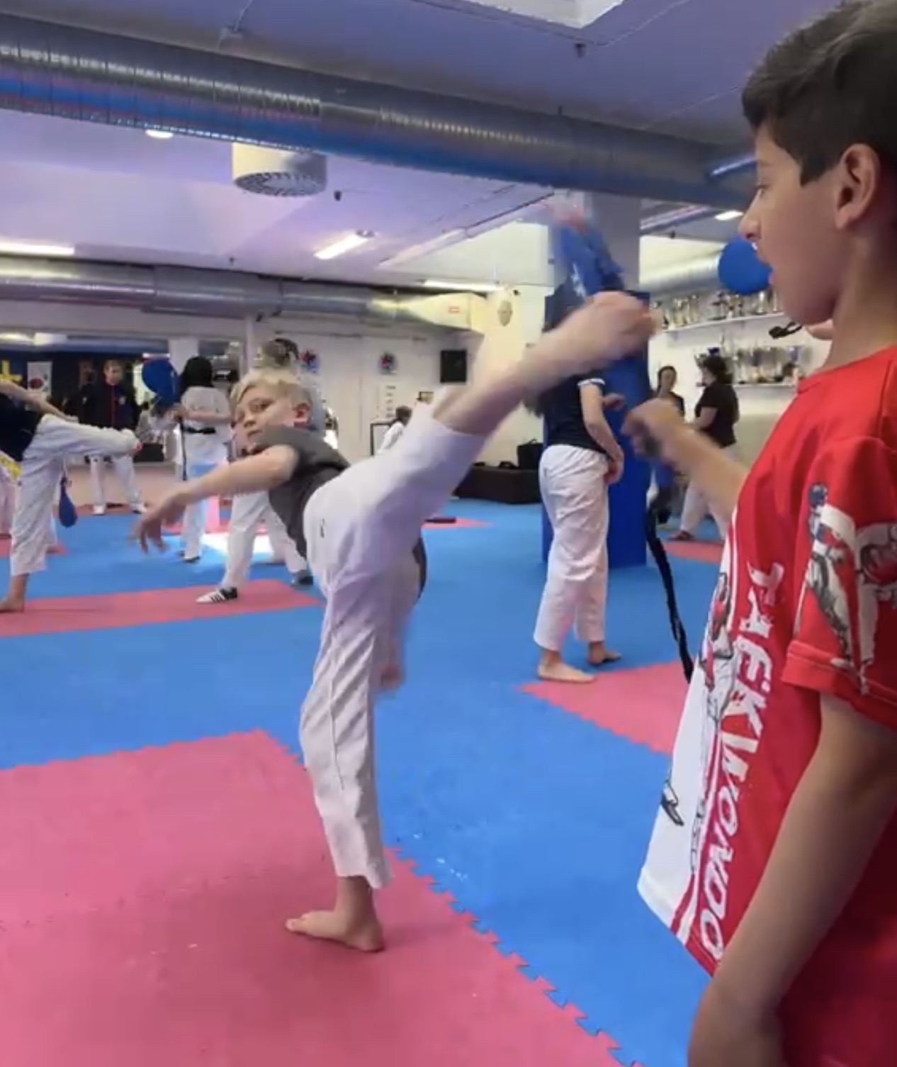 Pojke tränar högt spark under Taekwondopass